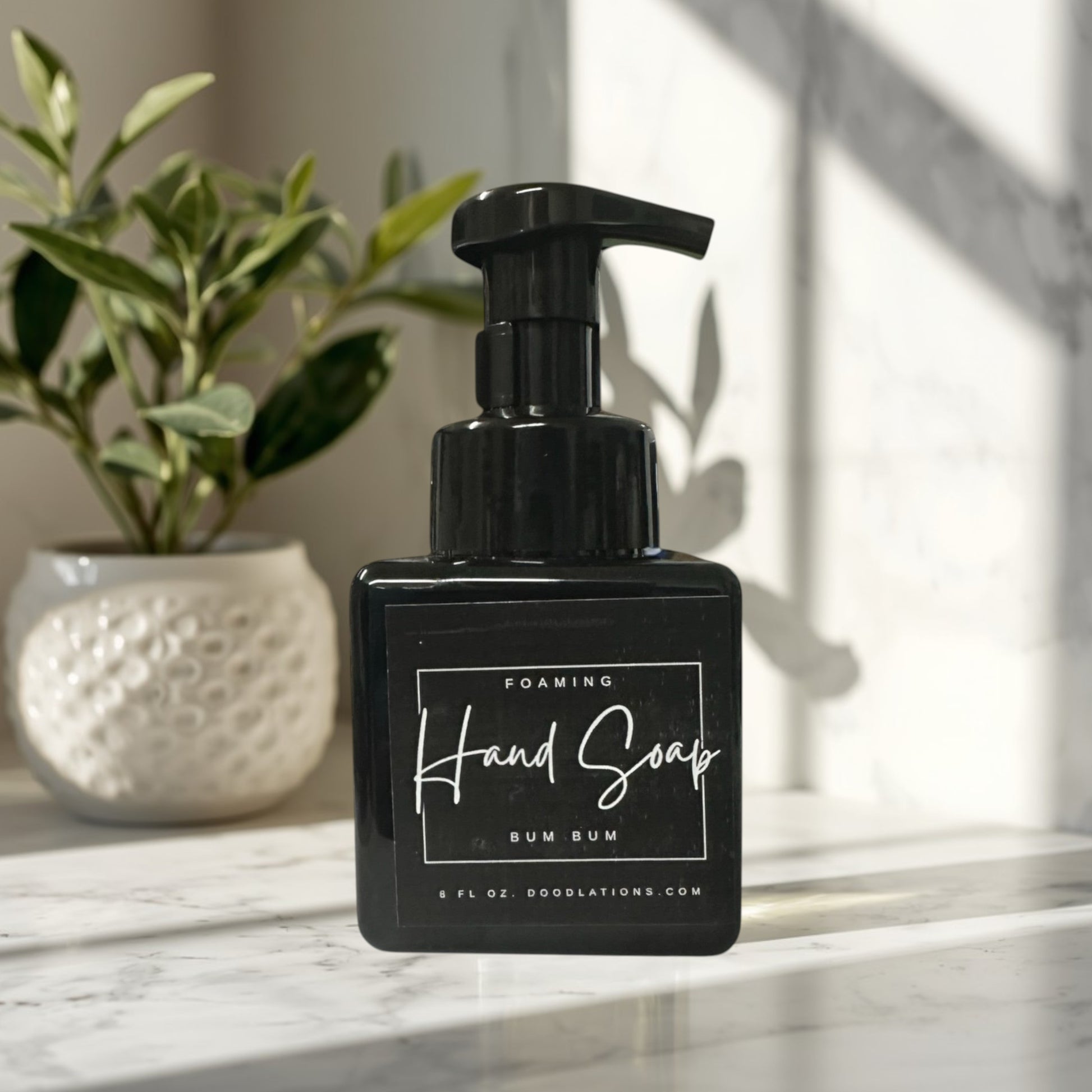 Bum Bum foaming hand soap in a black bottle with a tropical floral background.