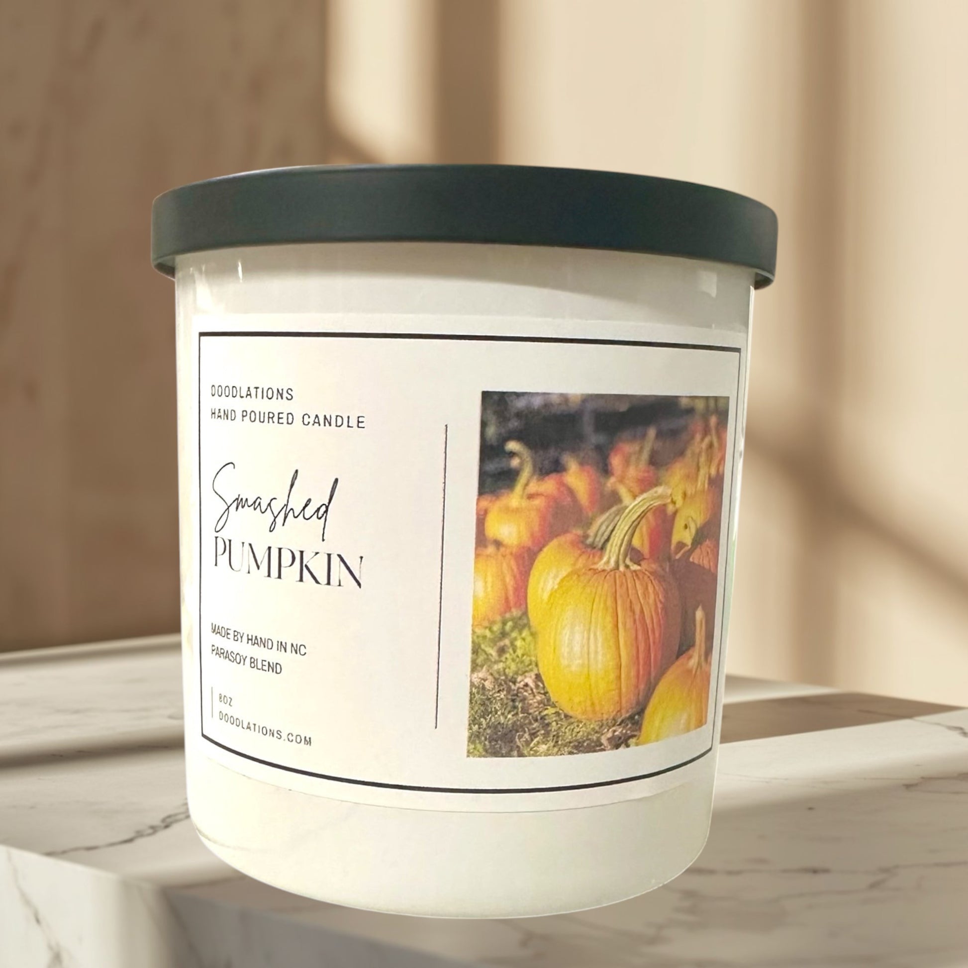 Doodlations Coffee Bar & Boutique Smashed Pumpkin hand-poured soy blend candle with a dark green lid.