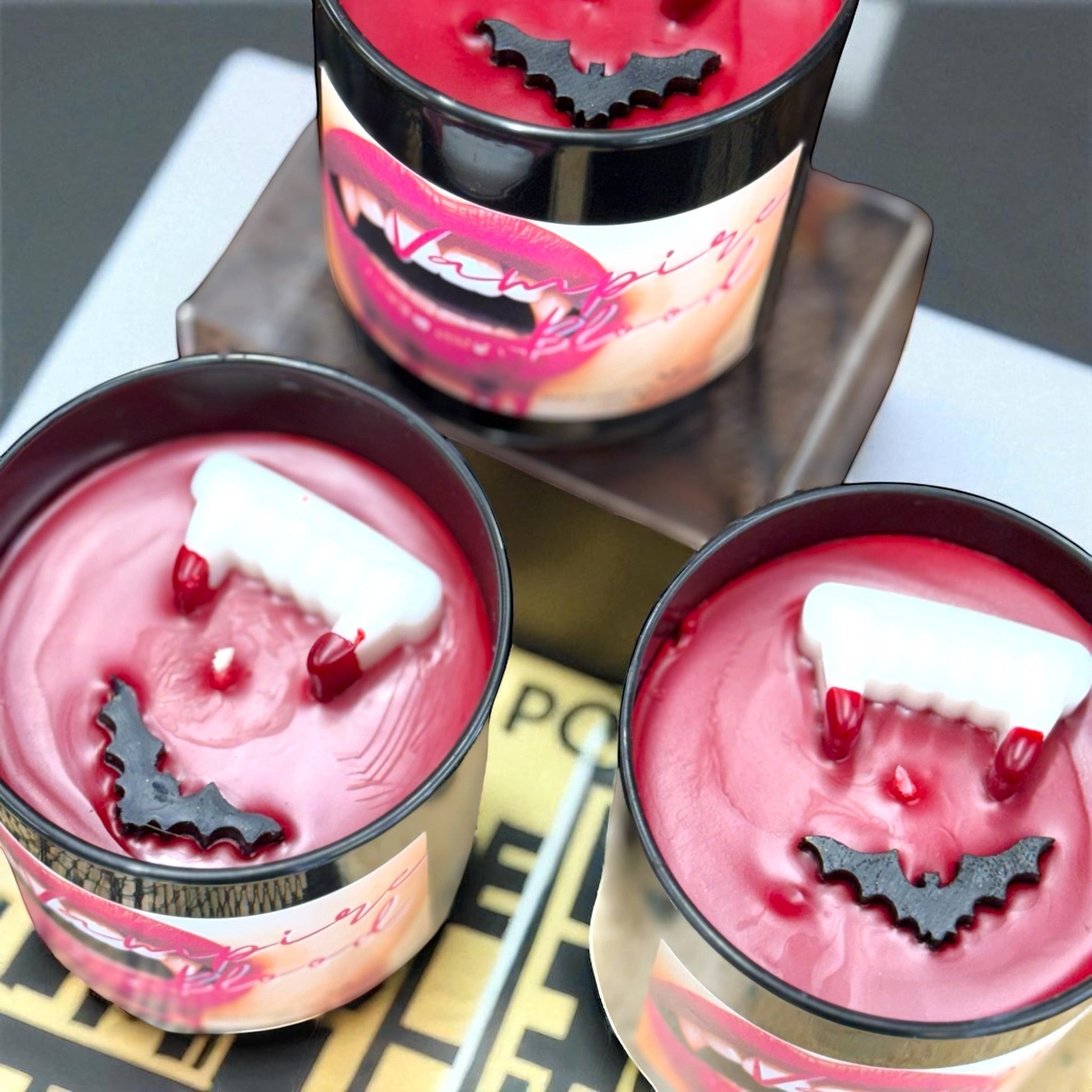 Vampire Blood luxury candle with decorative wax fangs and bats. Bold berry, jasmine, amber scent.