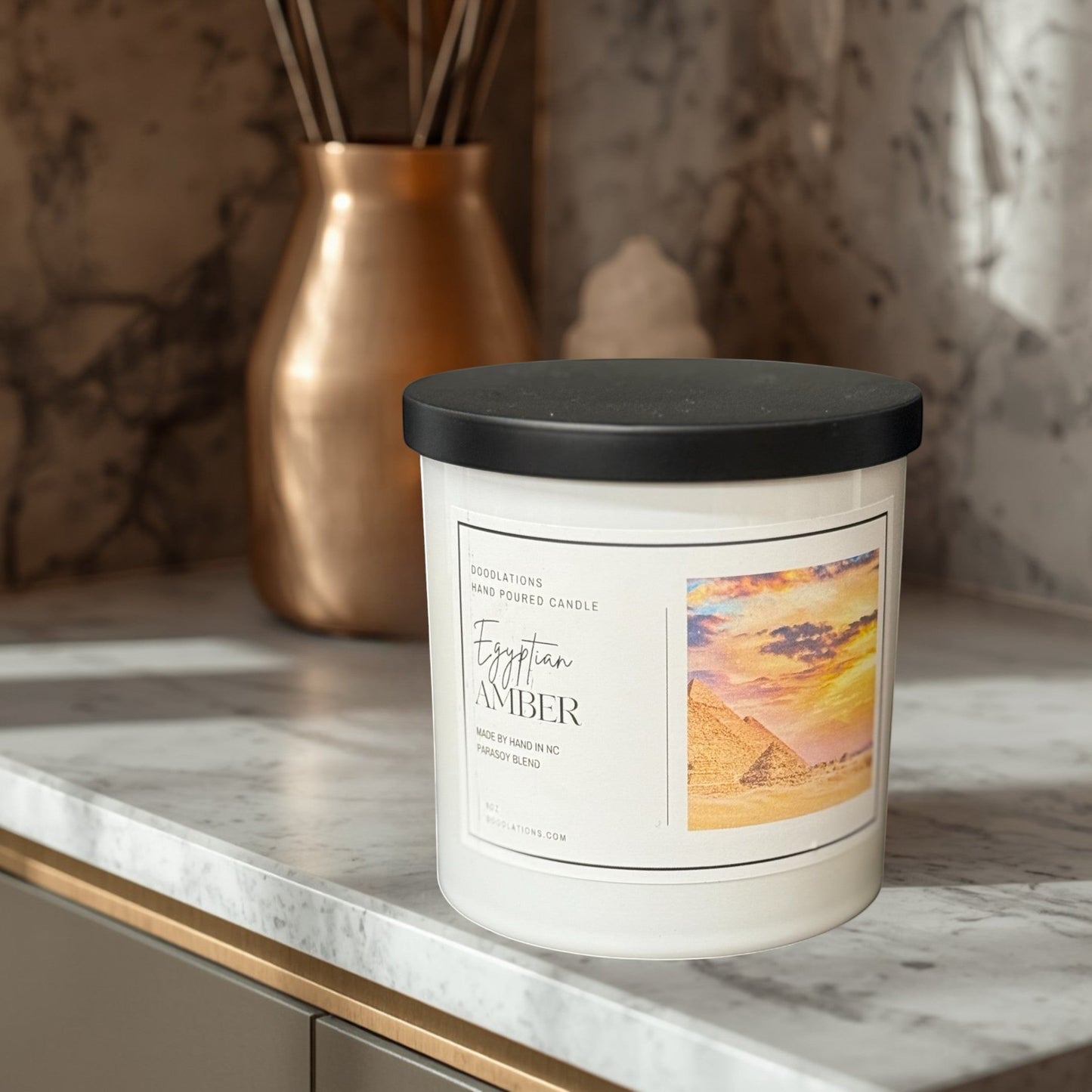 Egyptian Amber hand-poured soy blend candle in a white jar with a black lid.