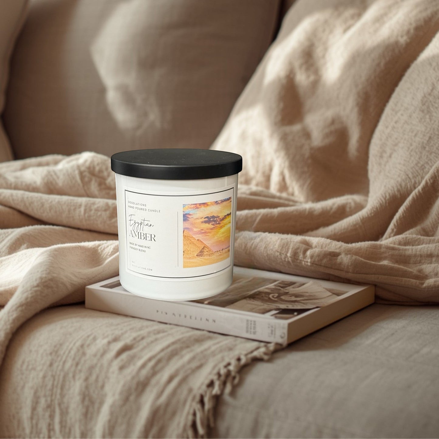 Egyptian Amber hand-poured soy blend candle in a white jar with a black lid.