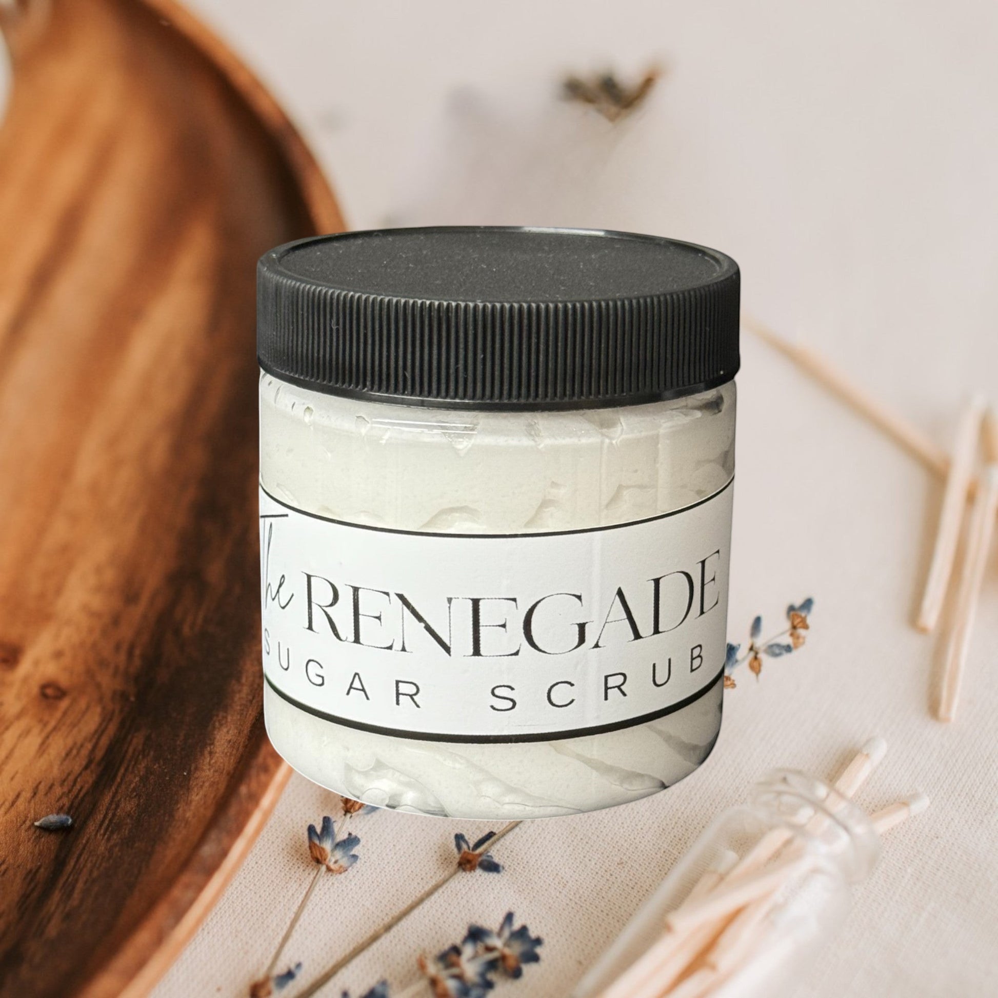 The Renegade Men's Sugar Scrub in a clear jar with a black lid. White textured scrub inside.