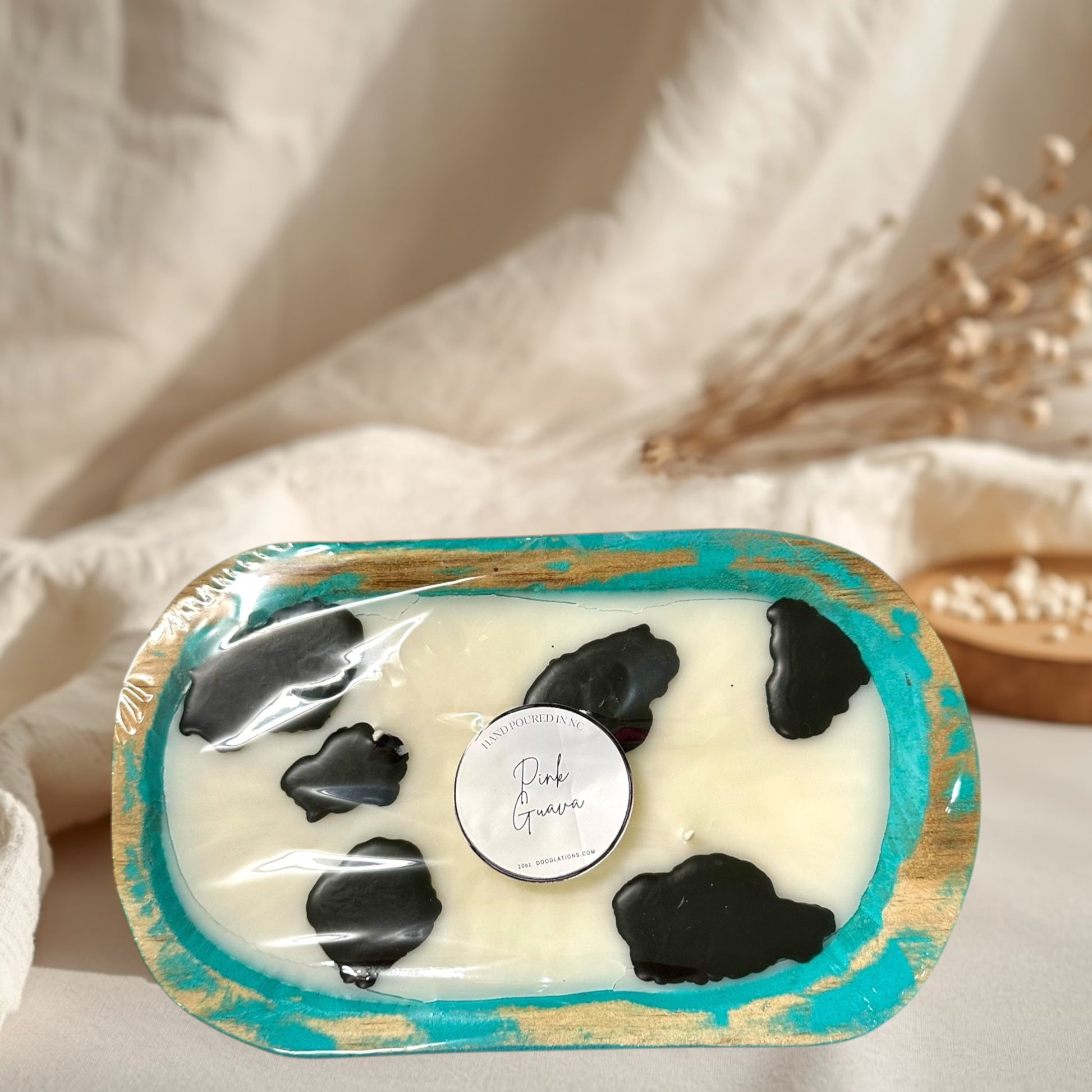 cow dough bowl candle in pink guava scent, with black cow spots.