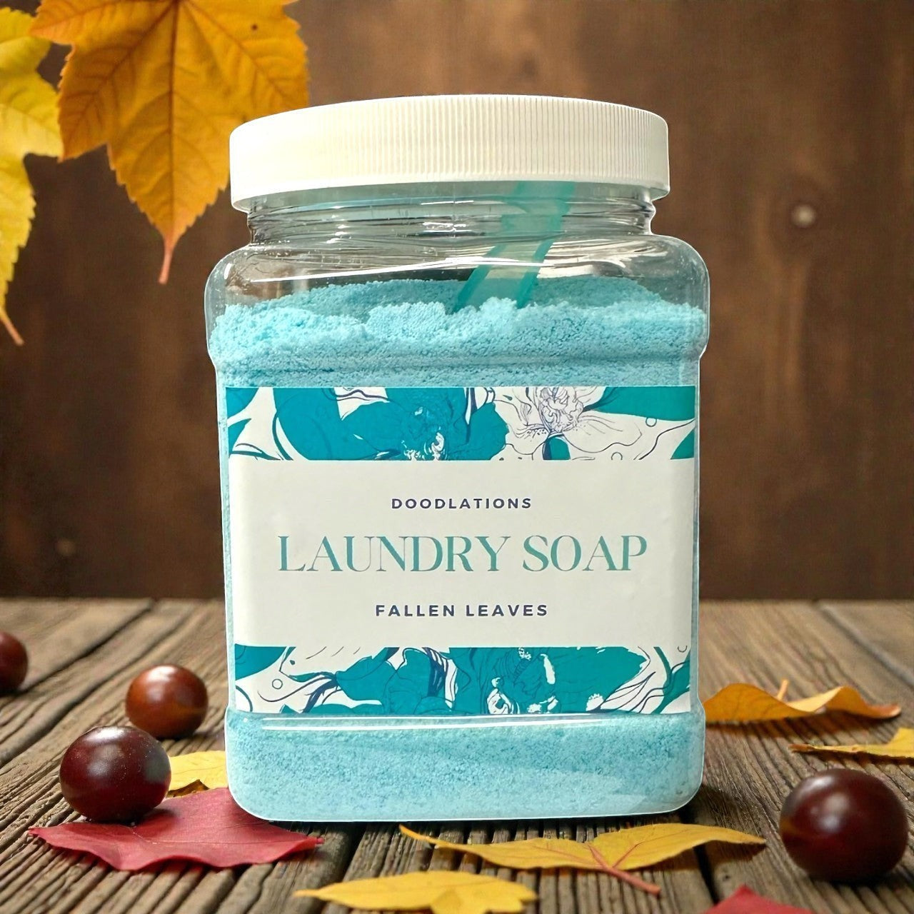 Doodlations Powder Laundry Detergent in Fallen Leaves scent, a bright blue powder in a clear plastic jar with a white lid.