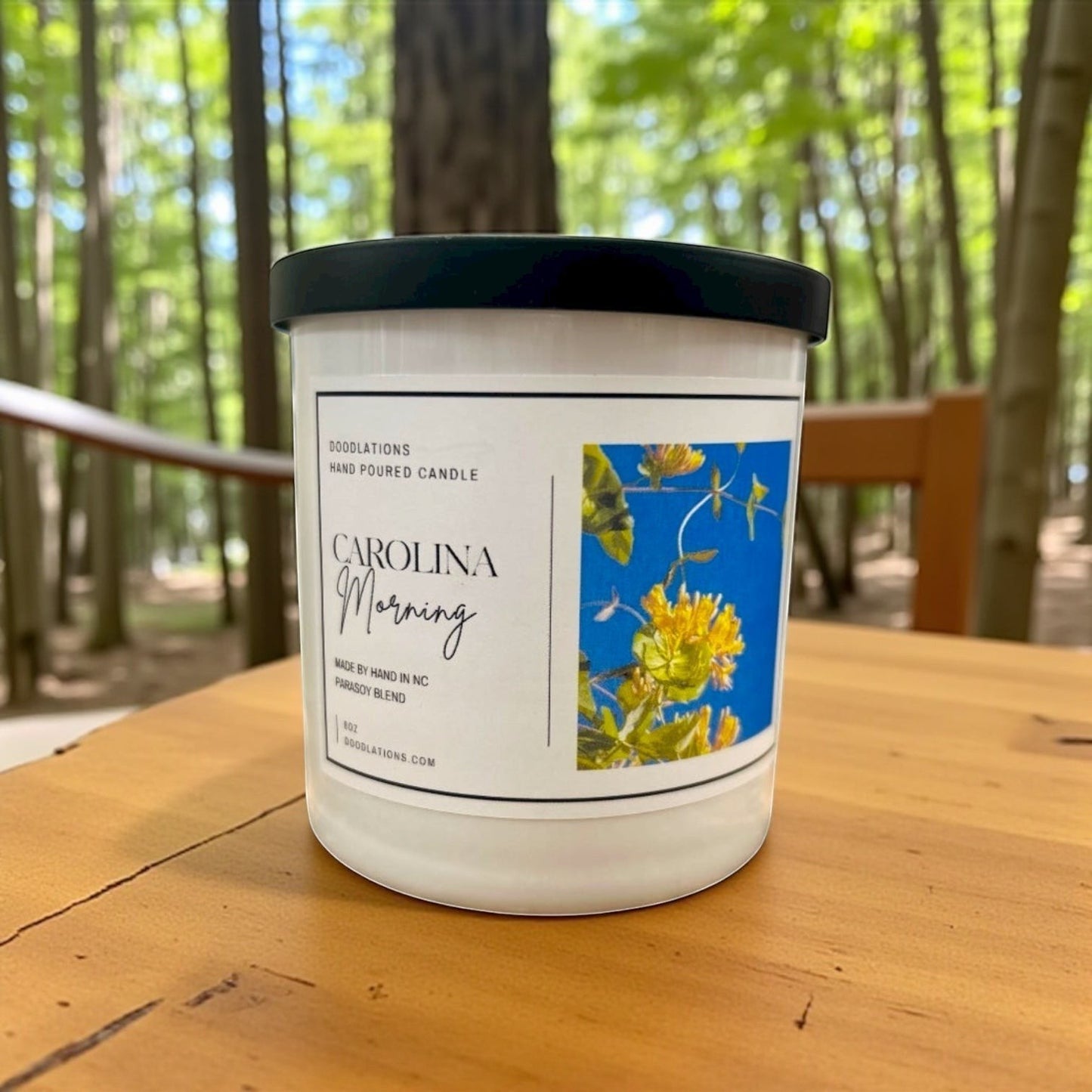 Doodlations Coffee Bar & Boutique Carolina Morning hand-poured soy blend candle with floral label.