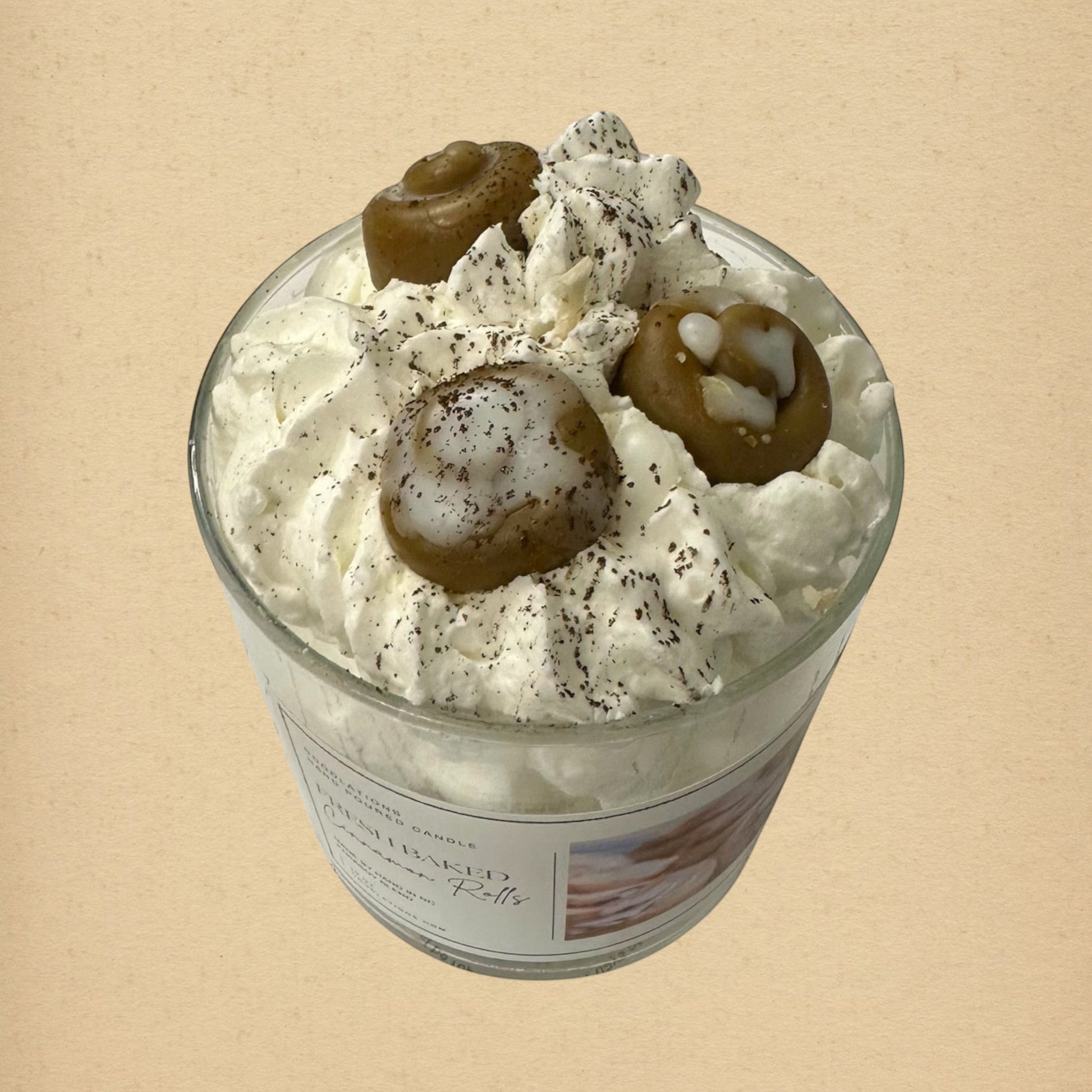 Cinnamon Bun candle with decorative wax toppings resembling cinnamon rolls and whipped cream.