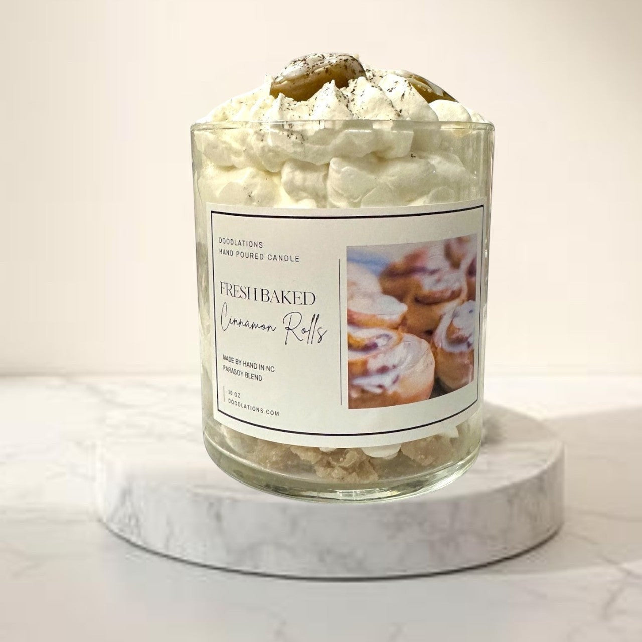 Doodlations Coffee Bar & Boutique Cinnamon Bun candle with decorative wax toppings resembling cinnamon rolls and whipped cream.