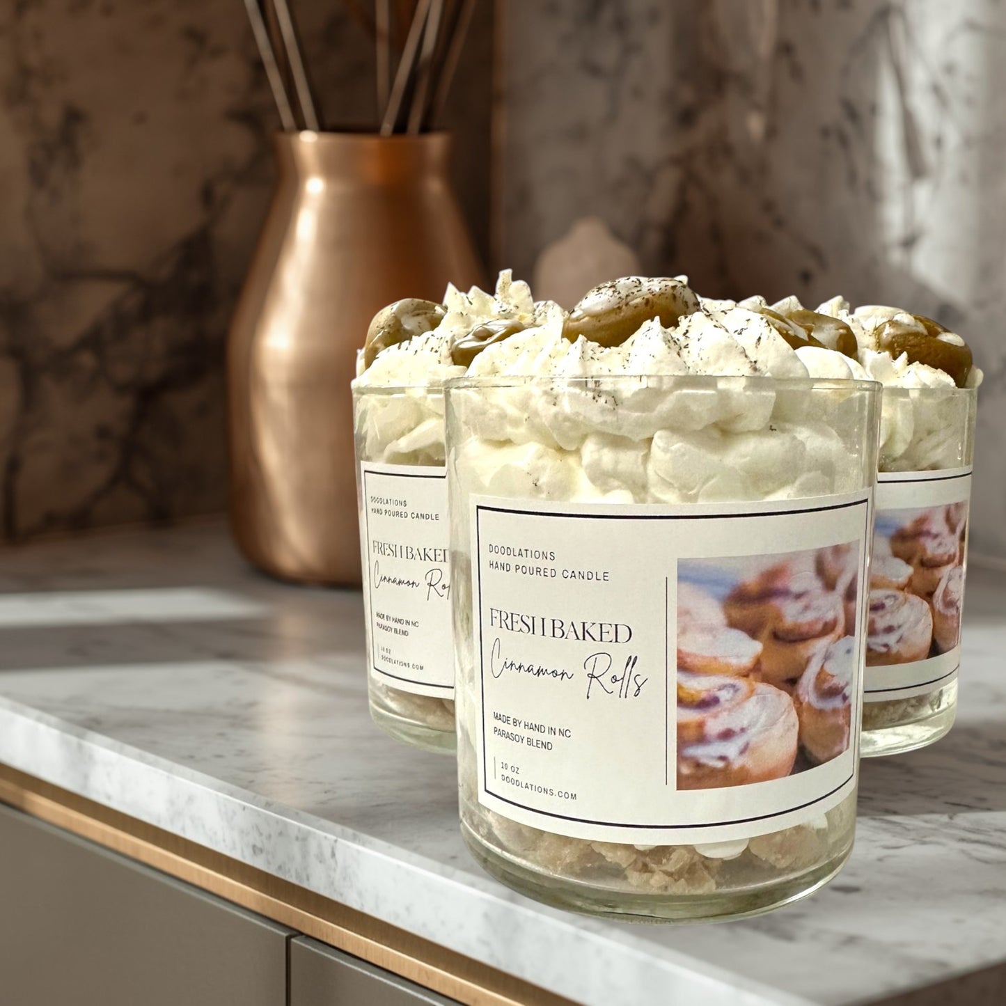 Doodlations Coffee Bar & Boutique Cinnamon Bun candle with decorative wax toppings resembling cinnamon rolls and whipped cream.
