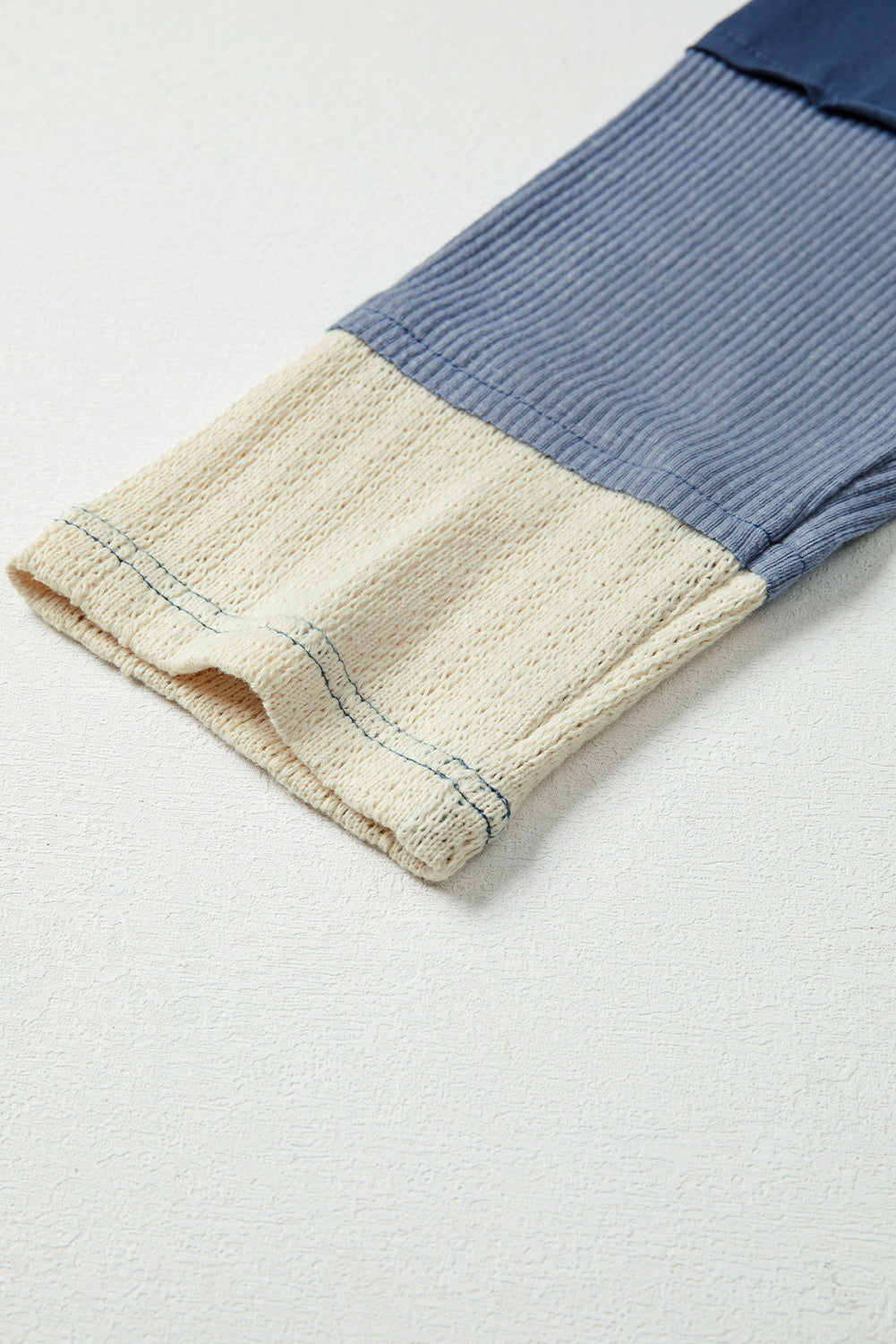 Close-up of a folded fabric with blue and beige colors on a light gray background