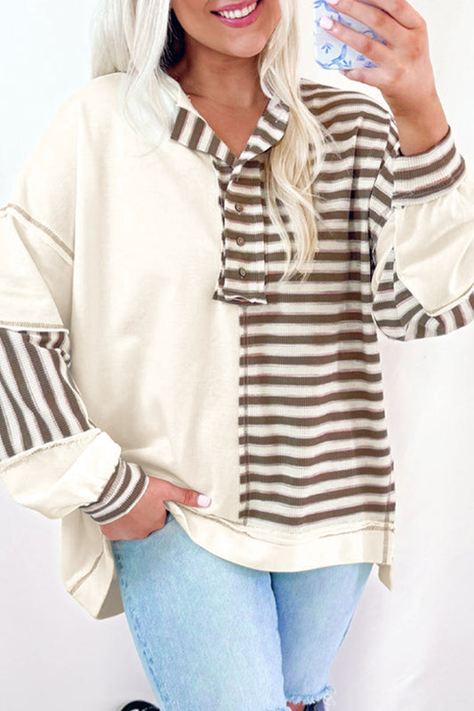 Woman wearing a striped shirt with long sleeves, holding a water bottle.