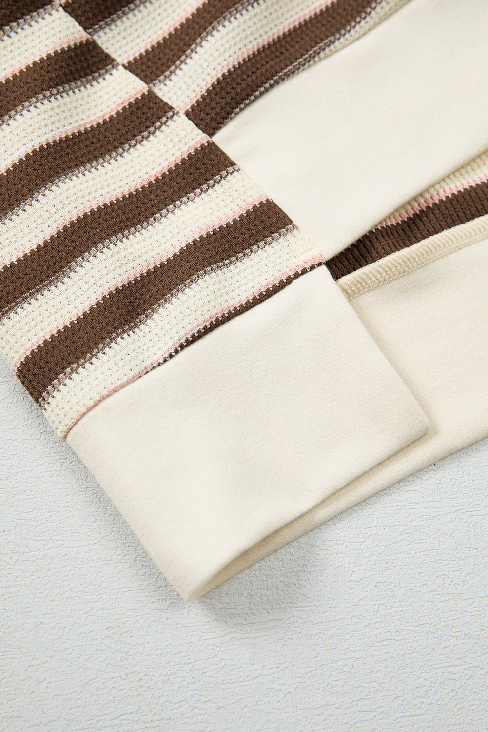 Close-up of a striped fabric with brown and beige colors on a light gray background