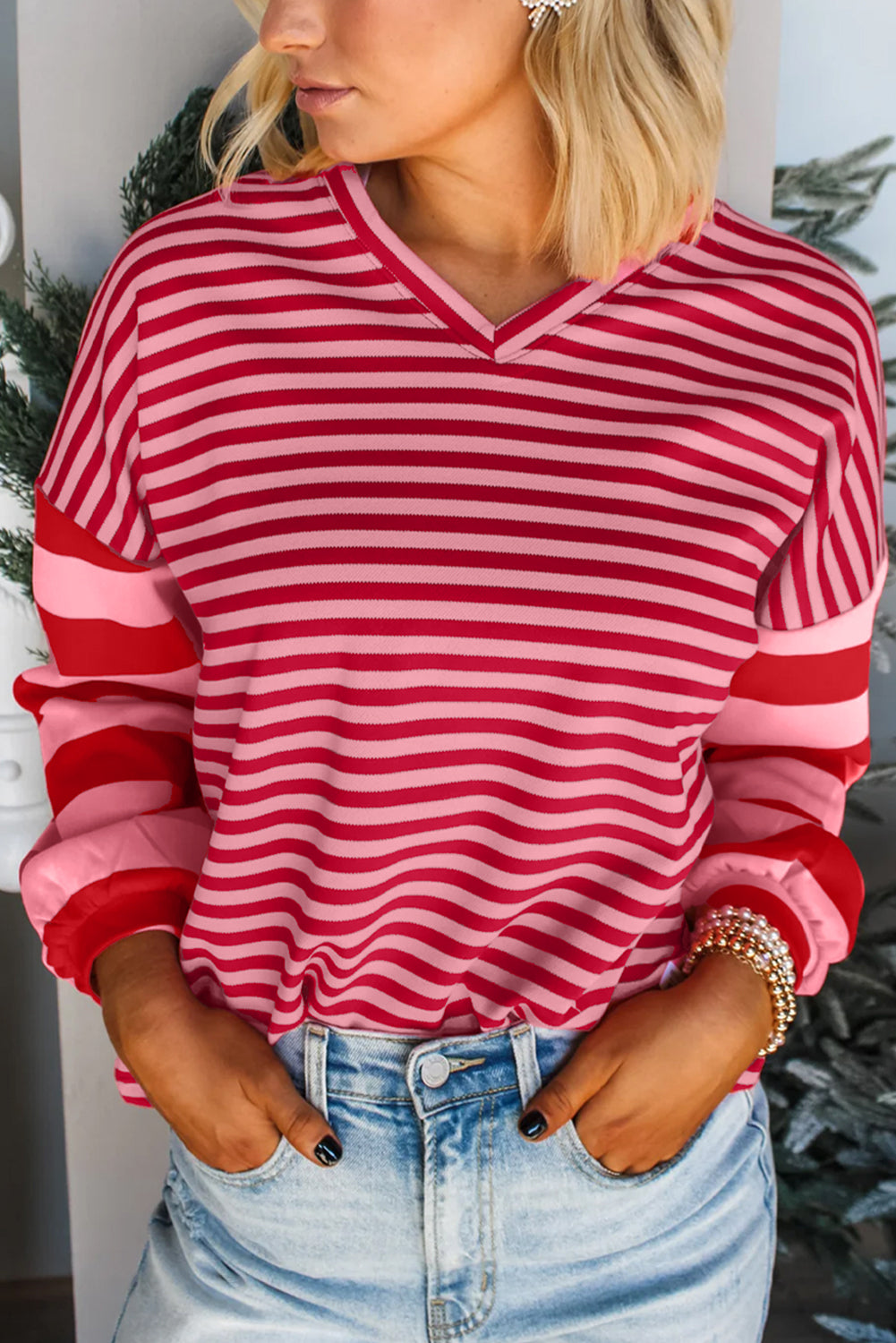Person wearing a red and pink striped shirt with a blurred background