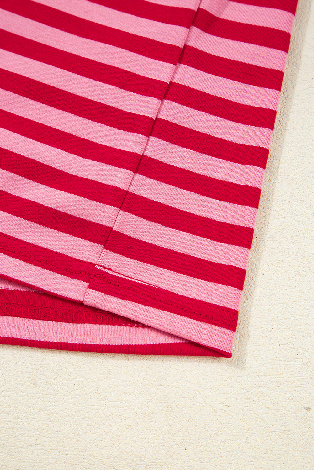 Close-up of a pink and red striped fabric on a white background