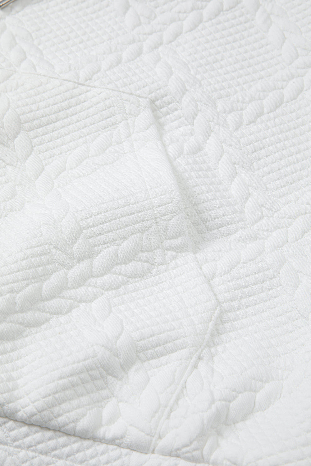 Close-up of a white quilted fabric texture