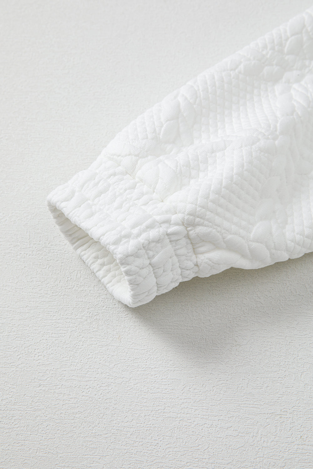 Close-up of a textured white fabric on a light gray background