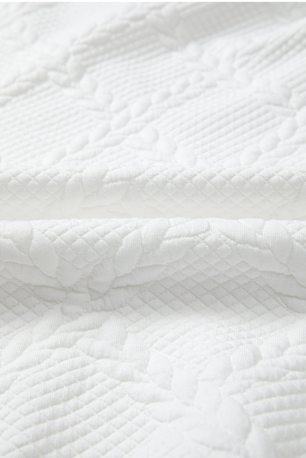 Close-up of a textured white fabric with a subtle pattern