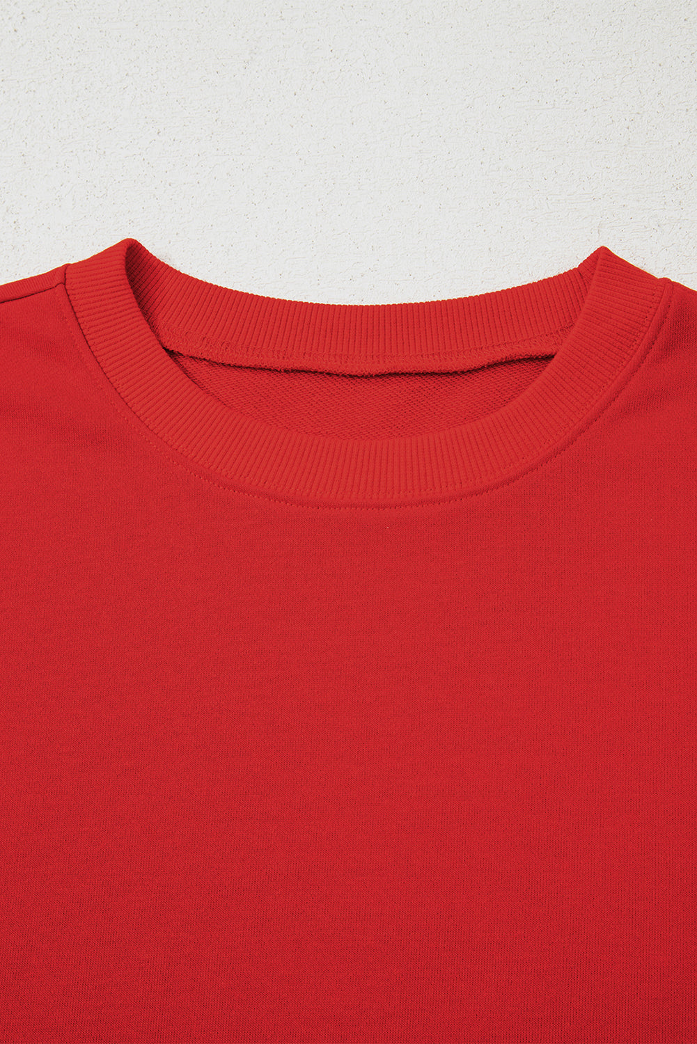 Close-up of a red shirt collar on a light gray background
