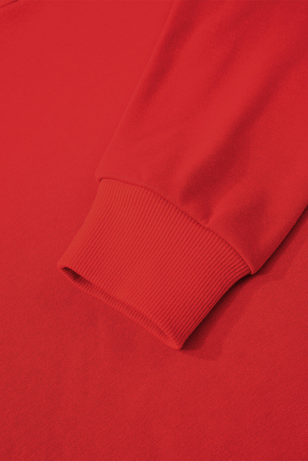 Close-up of a red sweater sleeve on a matching red background