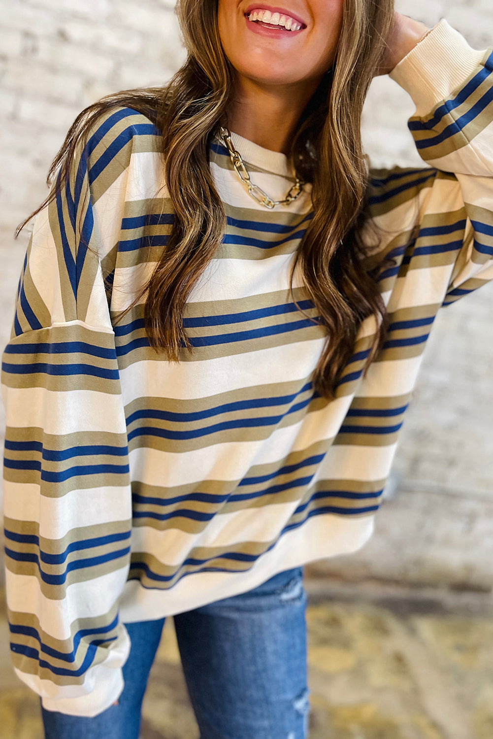 Woman wearing a striped long-sleeve shirt with a blurred background