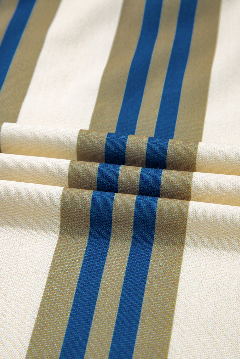 Close-up of fabric with blue and beige stripes on a white background