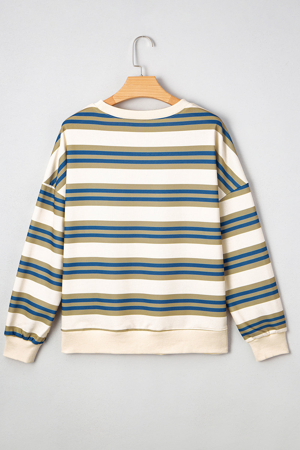 Striped sweater on a hanger against a gray background