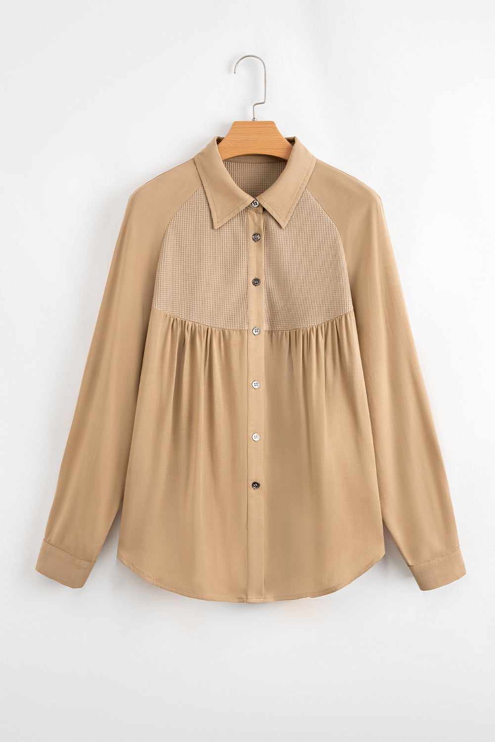 Beige shirt on a hanger against a white background