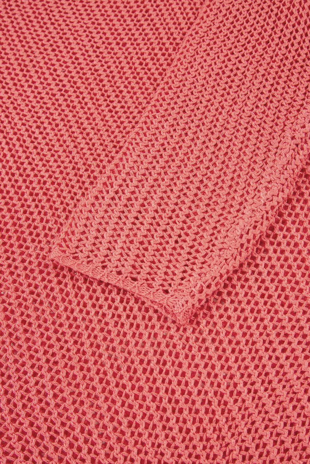 Close-up of a textured pink fabric with a pocket.