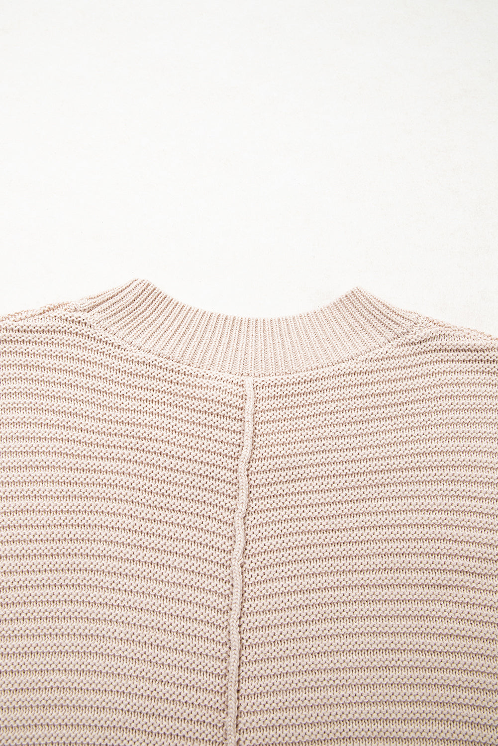 Close-up of a beige knitted sweater on a white background