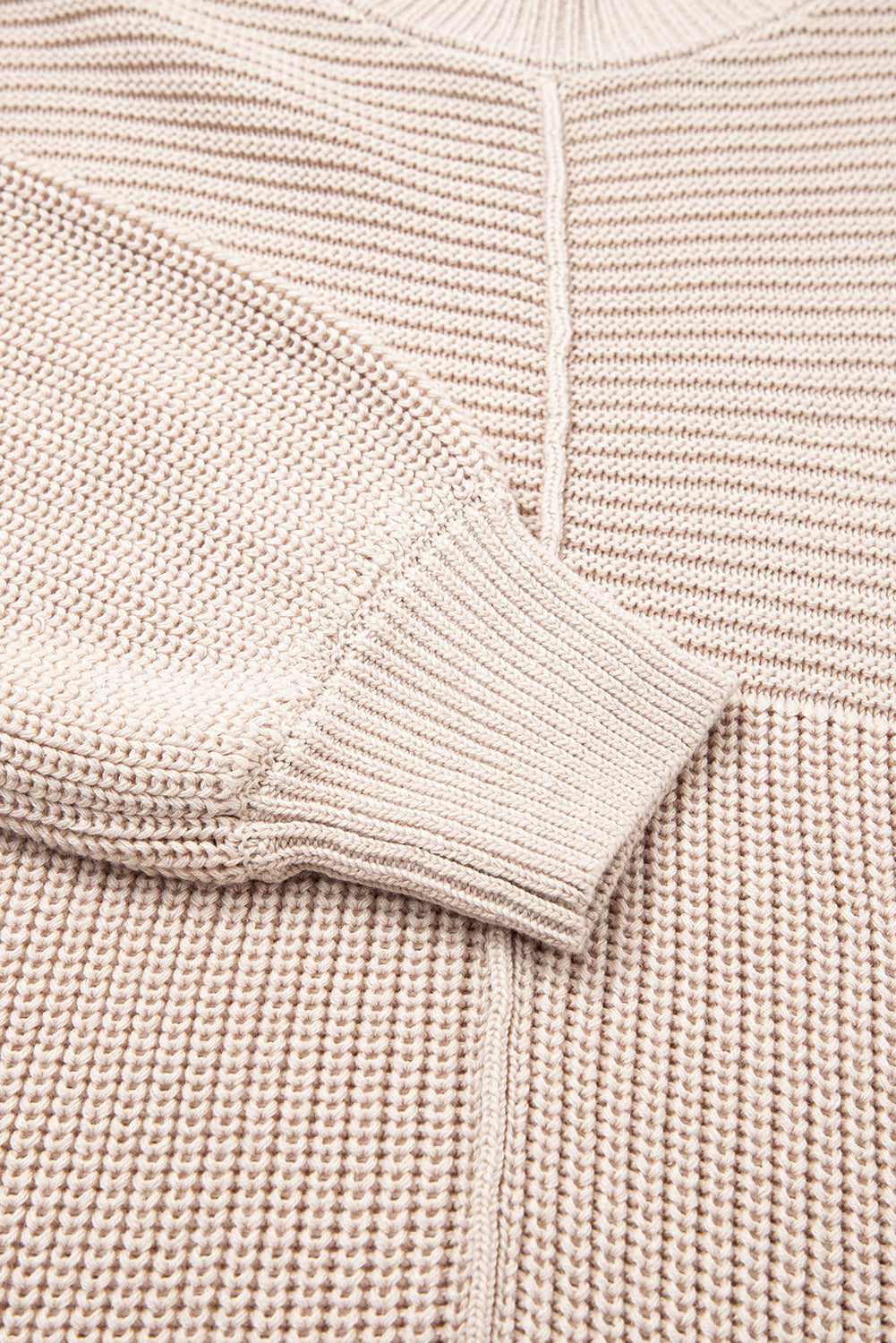 Close-up of a pink knit sweater with a focus on the sleeve and fabric texture.