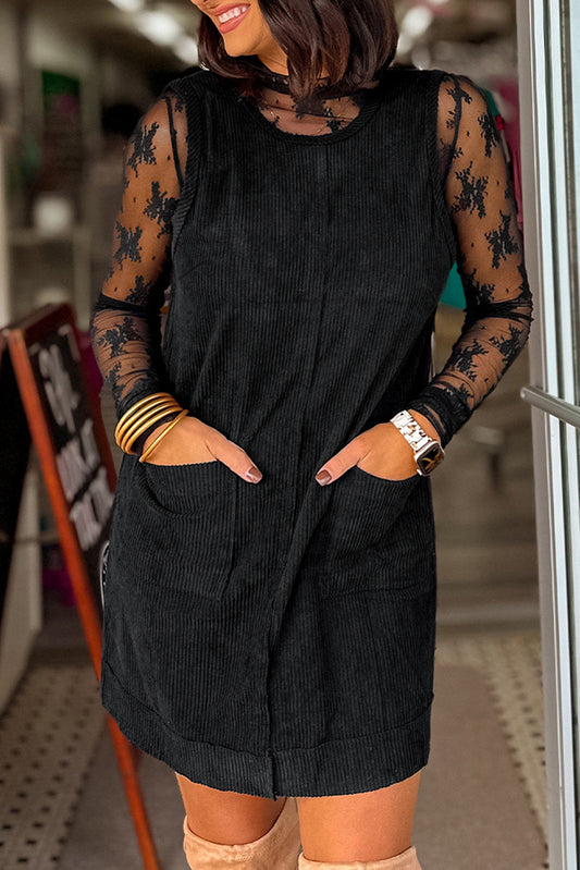 Woman wearing a black dress with sheer sleeves in an indoor setting
