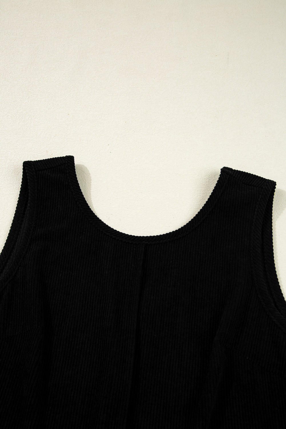 Black sleeveless top on a light beige background