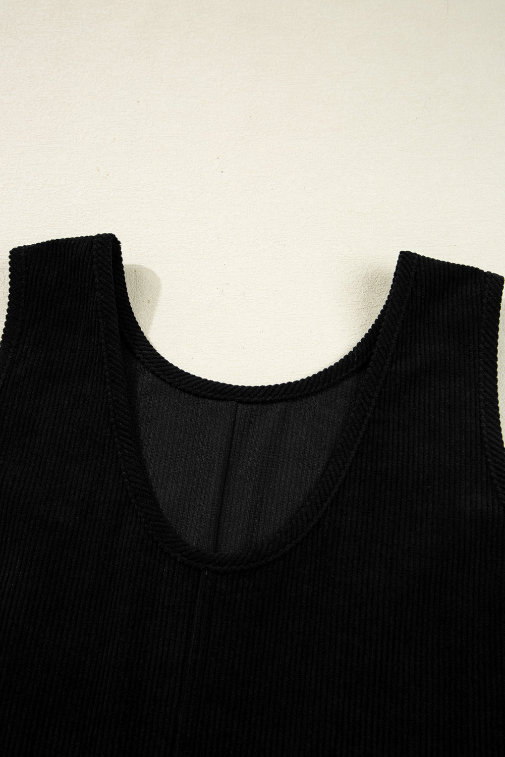 Black sleeveless top on a beige background