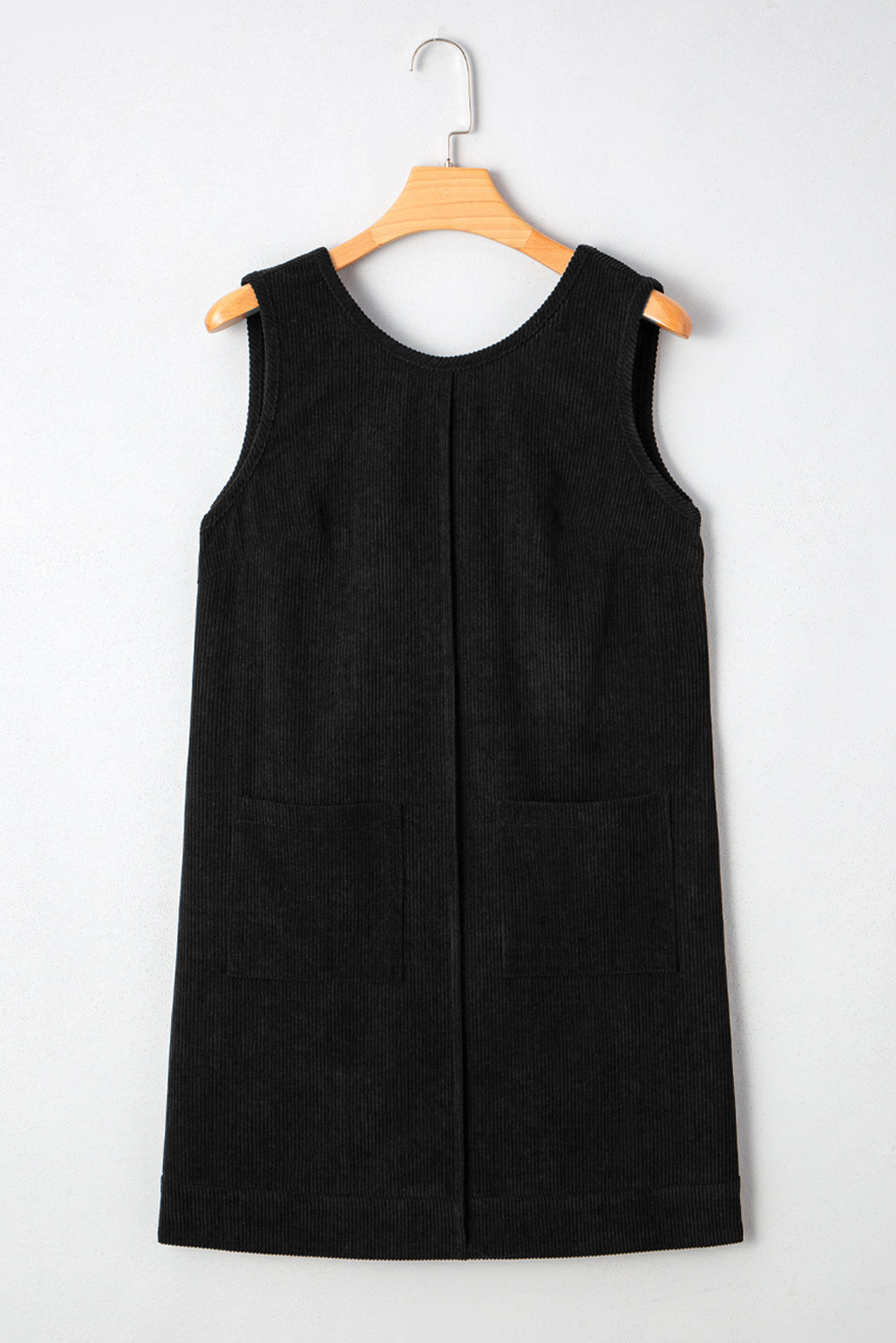 Black sleeveless dress on a wooden hanger against a white background