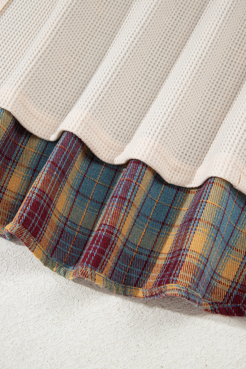 Close-up of a fabric edge with plaid pattern and textured surface