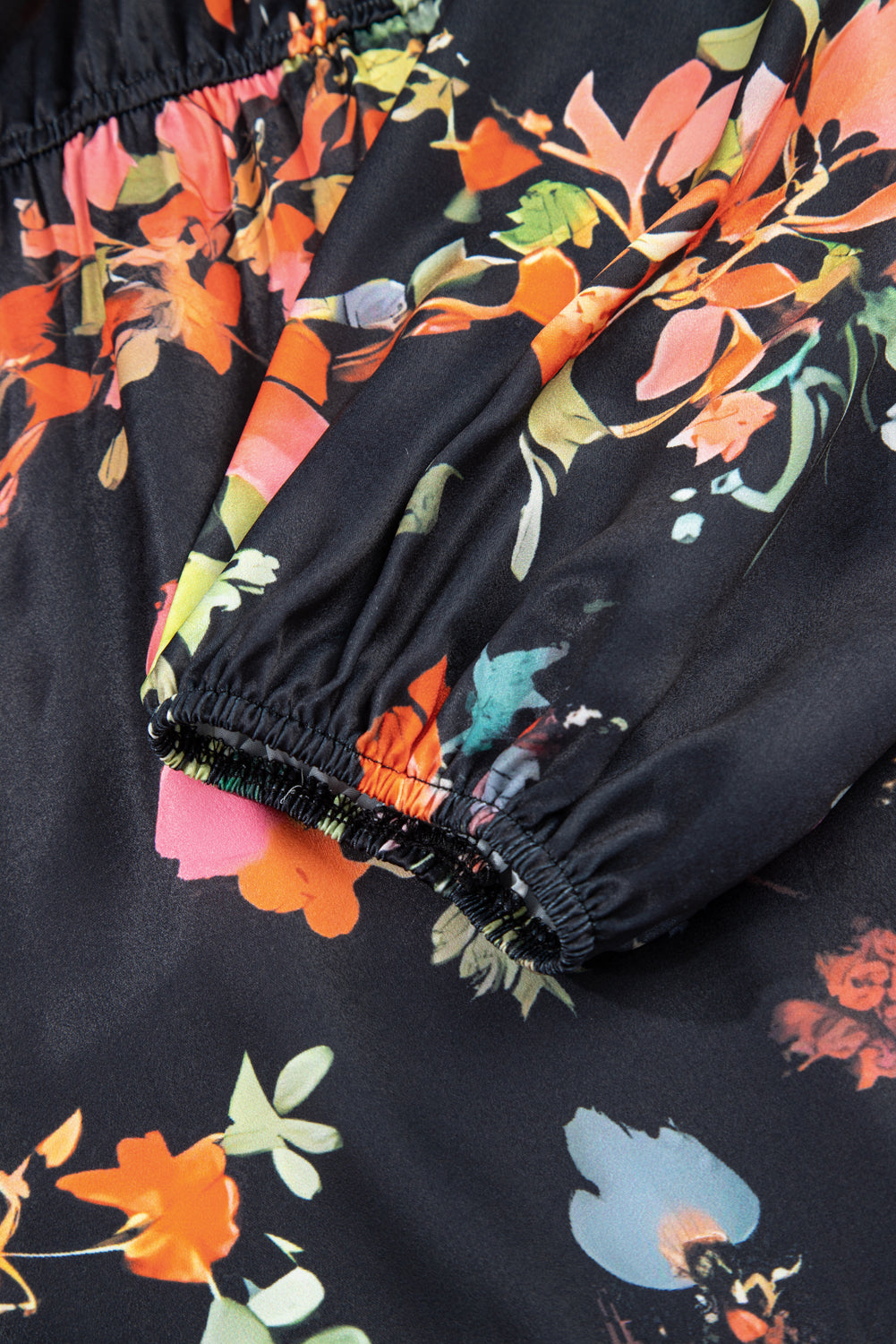 Close-up of a black garment with colorful floral pattern