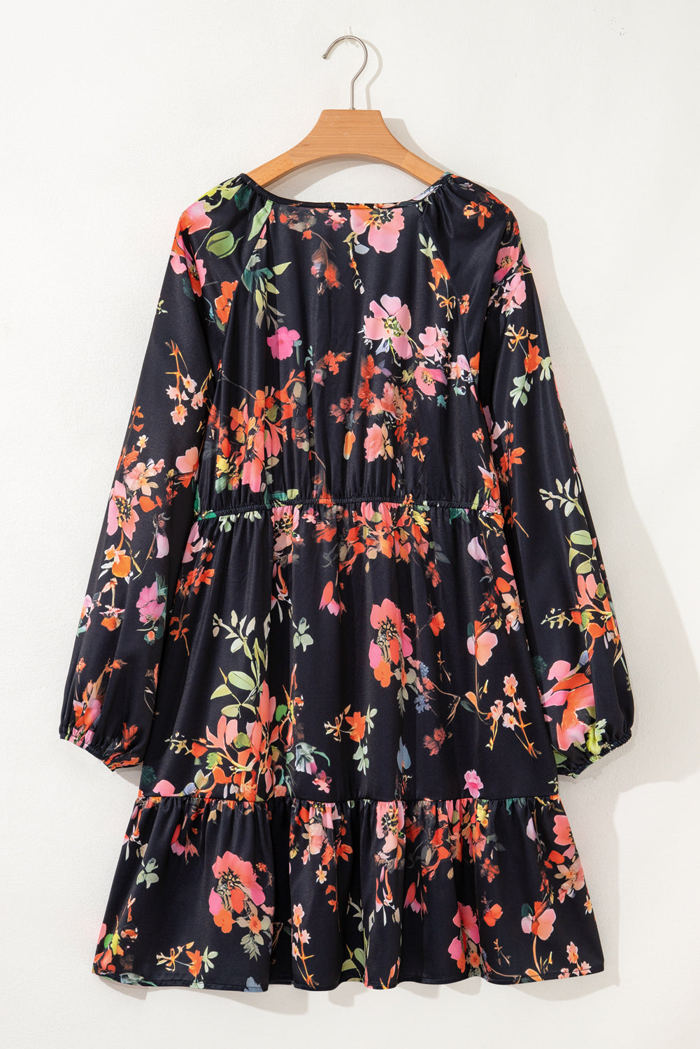 Floral dress on a hanger against a white background