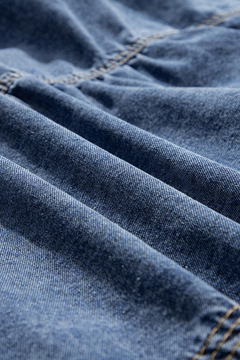 Close-up of blue denim fabric with stitching details