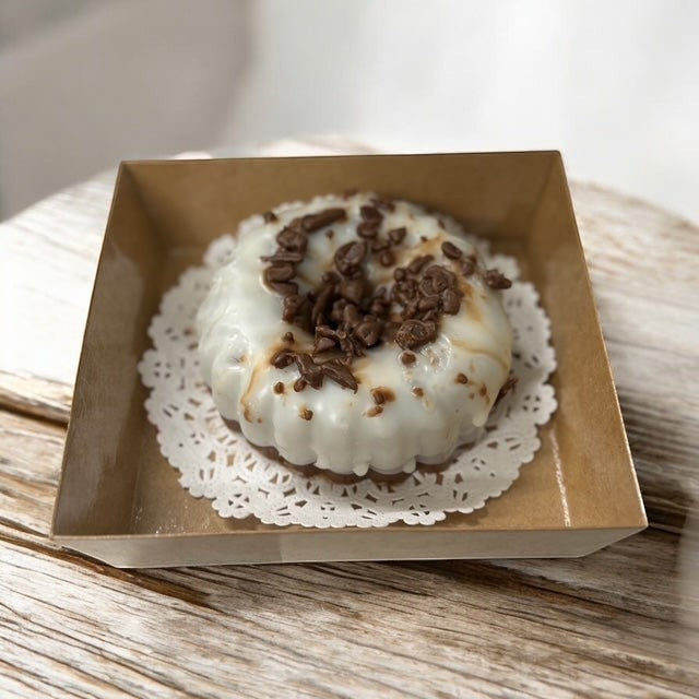Chocolate Pound Cake scented wax melt, shaped like a bundt cake with white icing and chocolate shavings.