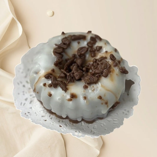 Chocolate Pound Cake scented wax melt, shaped like a bundt cake with white icing and chocolate shavings.