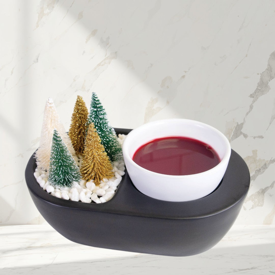black wax warmer with bottle brush trees and green wax melts.