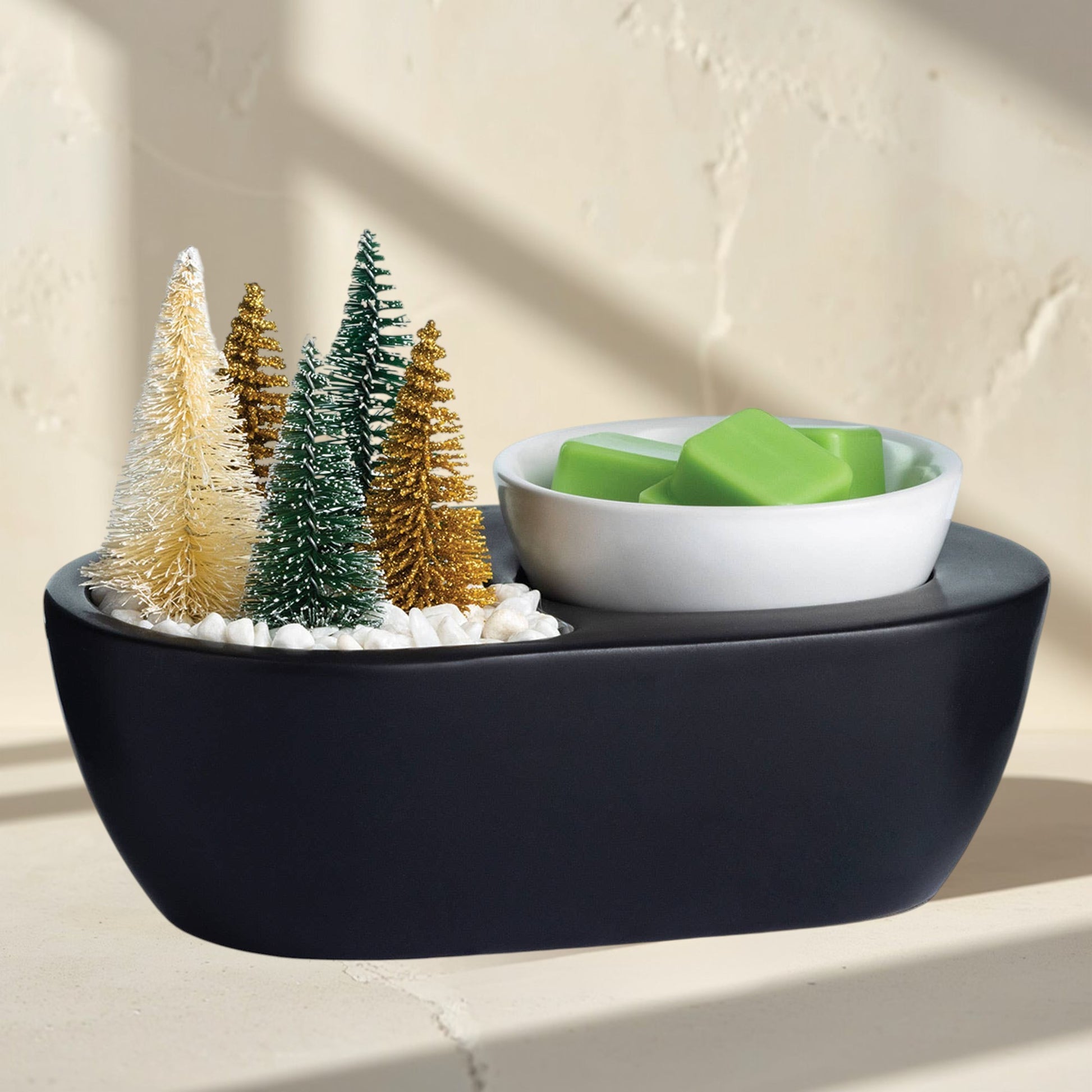 Doodlations 
black wax warmer with bottle brush trees and green wax melts.