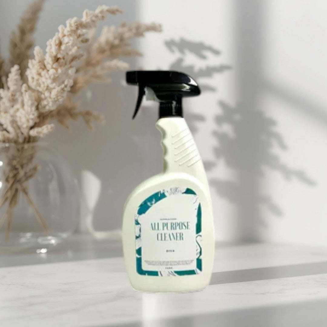 Doodlations All Purpose Cleaning Spray bottle with a teal and white label, set on a kitchen counter.