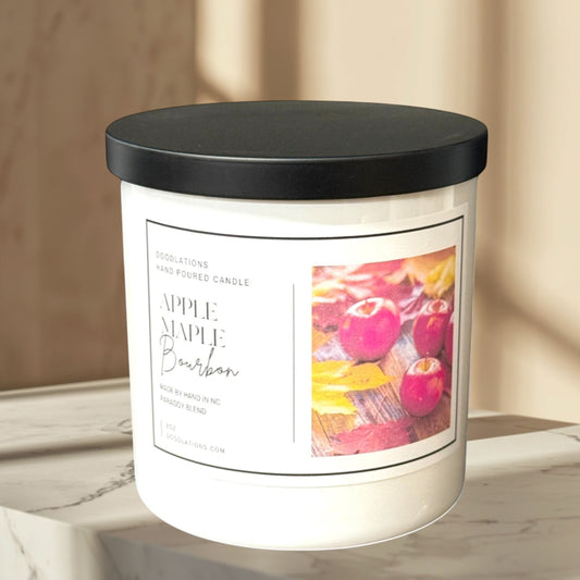 Doodlations Apples & Maple Bourbon hand-poured para-soy blend candle with a black lid.