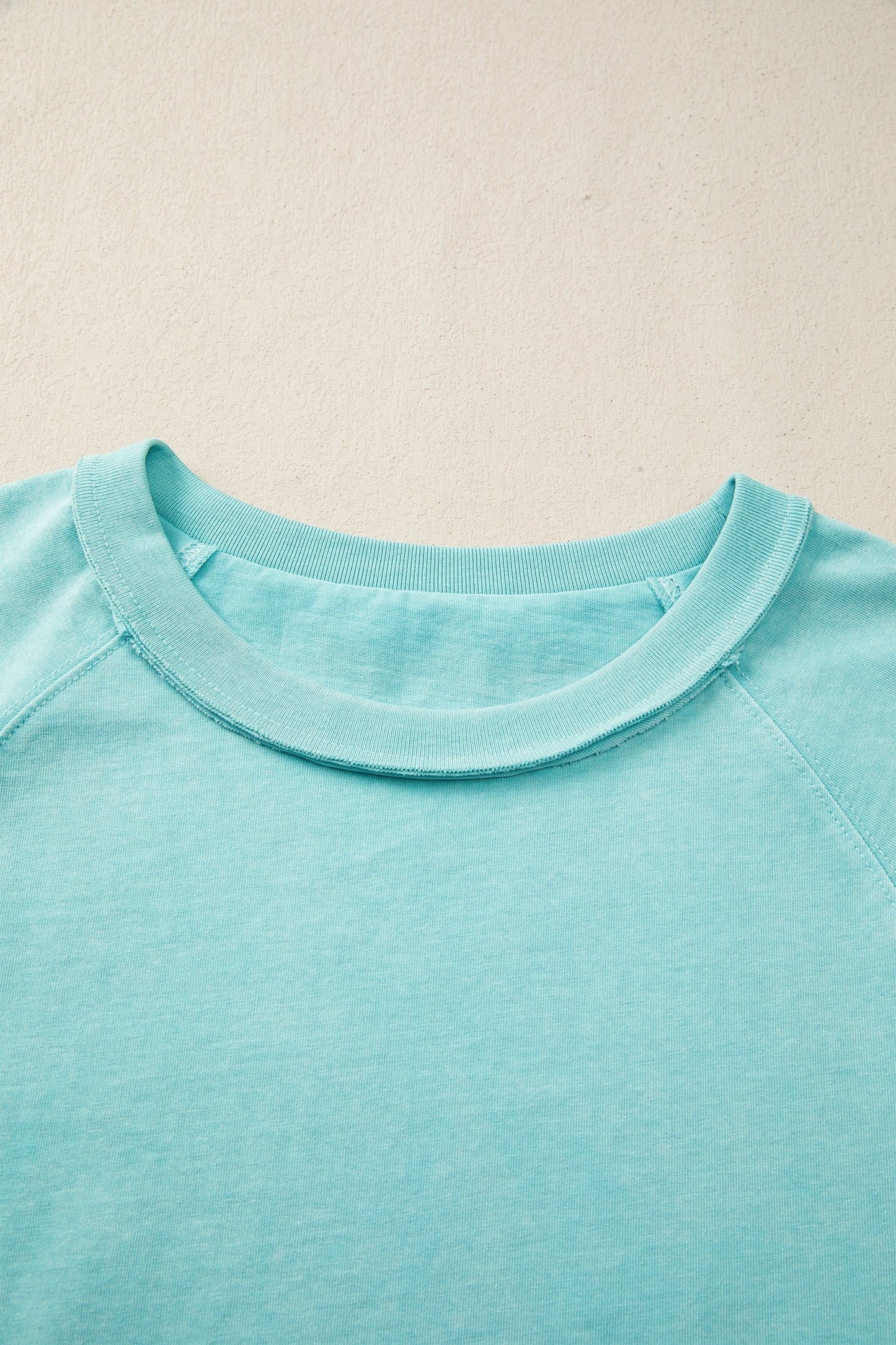 Doodlations Coffee Bar & Boutique teal mineral wash cotton blend relaxed fit tee with raw edge hem and sleeves.