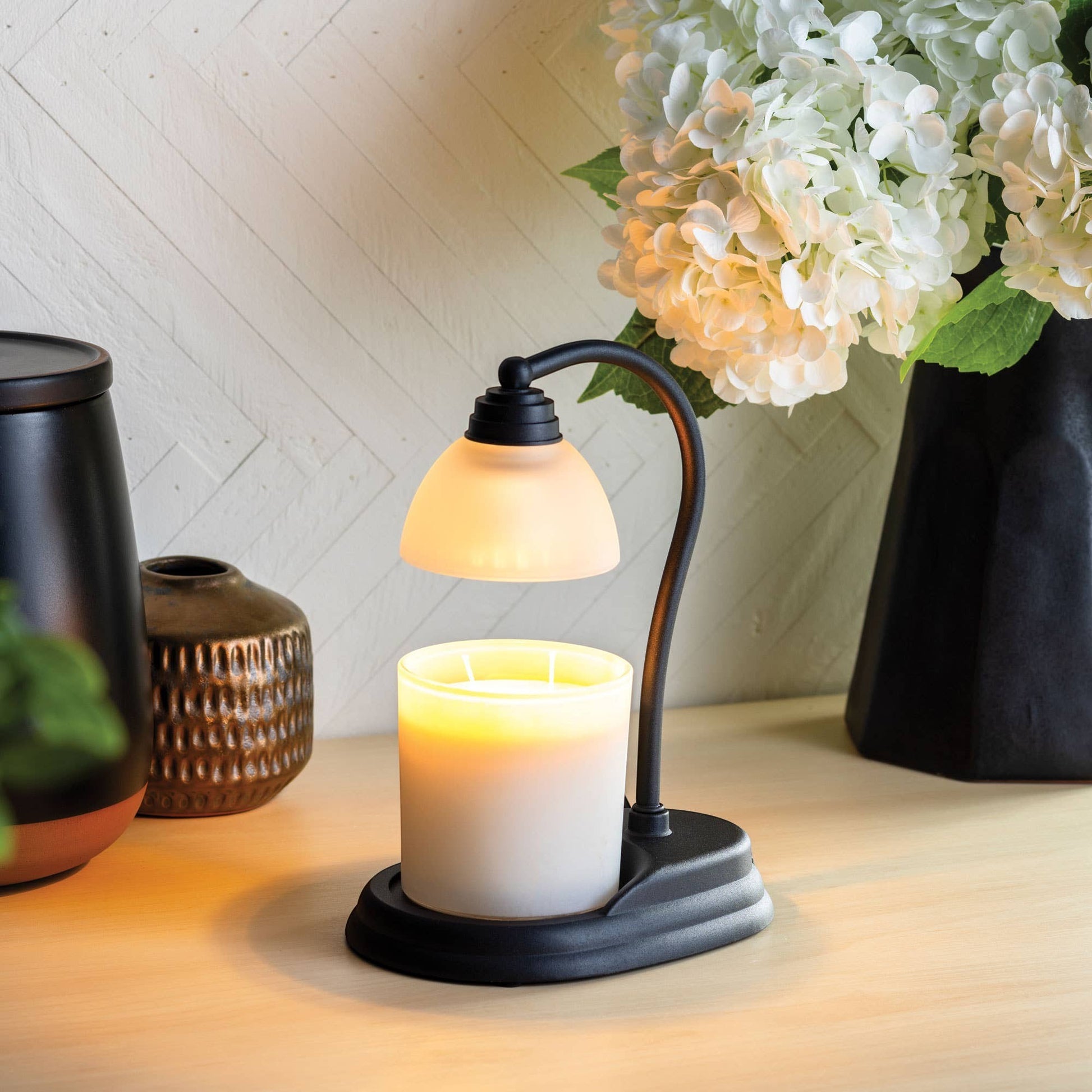Doodlations Aurora black candle warmer lamp with frosted shade melting a white candle.