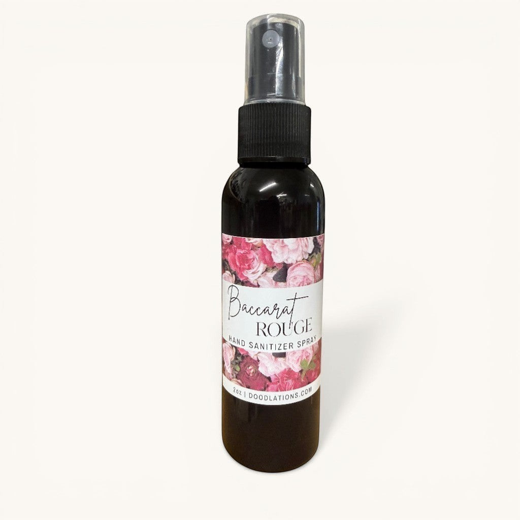 Doodlations Baccarat Rouge hand sanitizer spray with floral label and black cap. 2oz bottle.