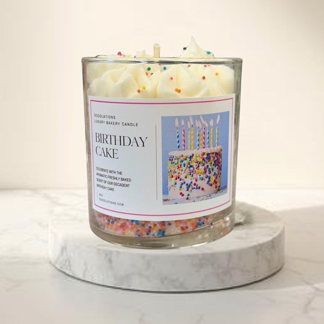 Doodlations Birthday Cake luxury bakery candle with white frosting and rainbow sprinkles in a glass jar.