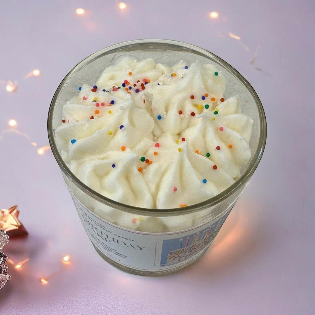 Doodlations Coffee Bar & Boutique Birthday Cake candle with white frosting and colorful sprinkles in a glass jar.