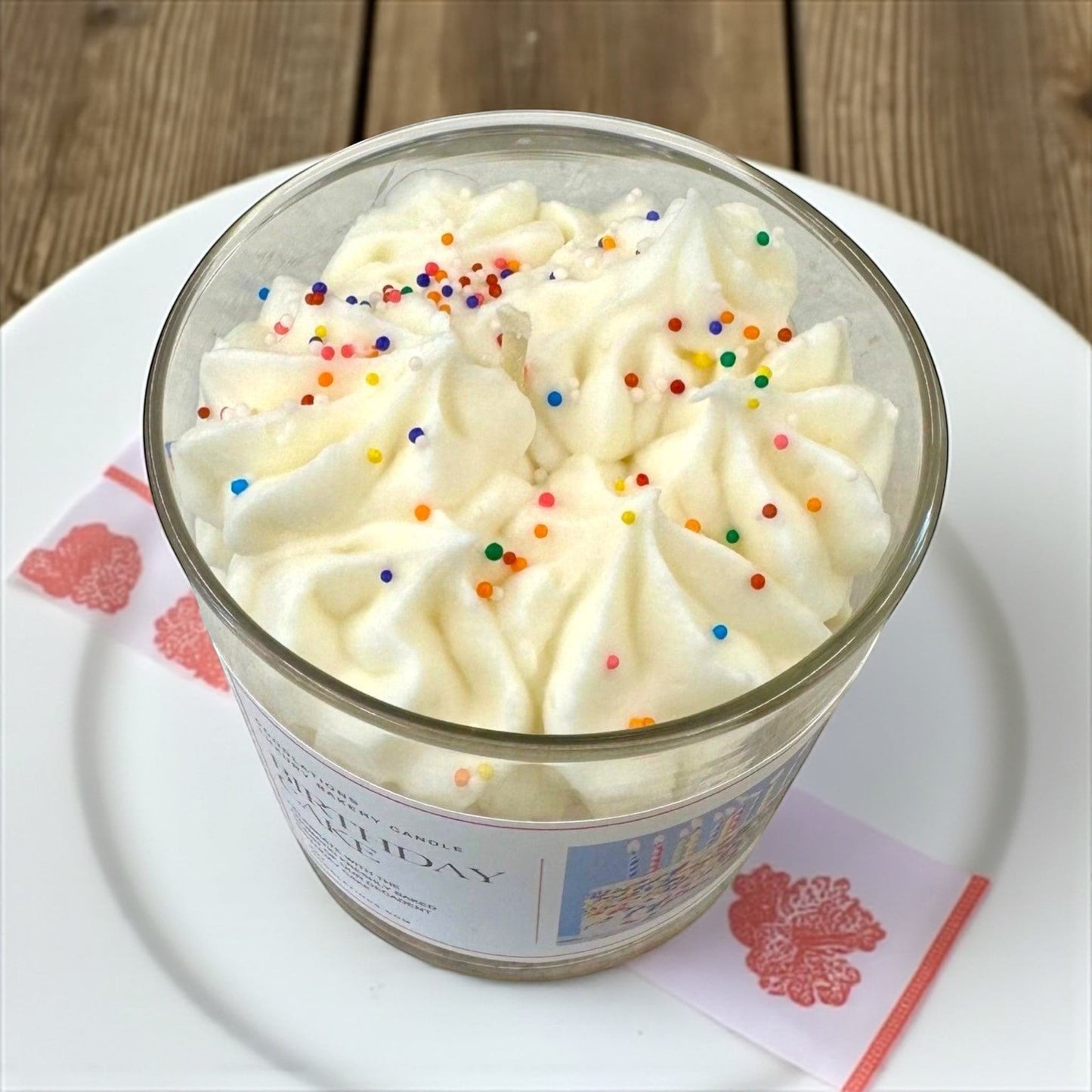 Doodlations Coffee Bar & Boutique Birthday Cake candle with white frosting and colorful sprinkles in a glass jar.