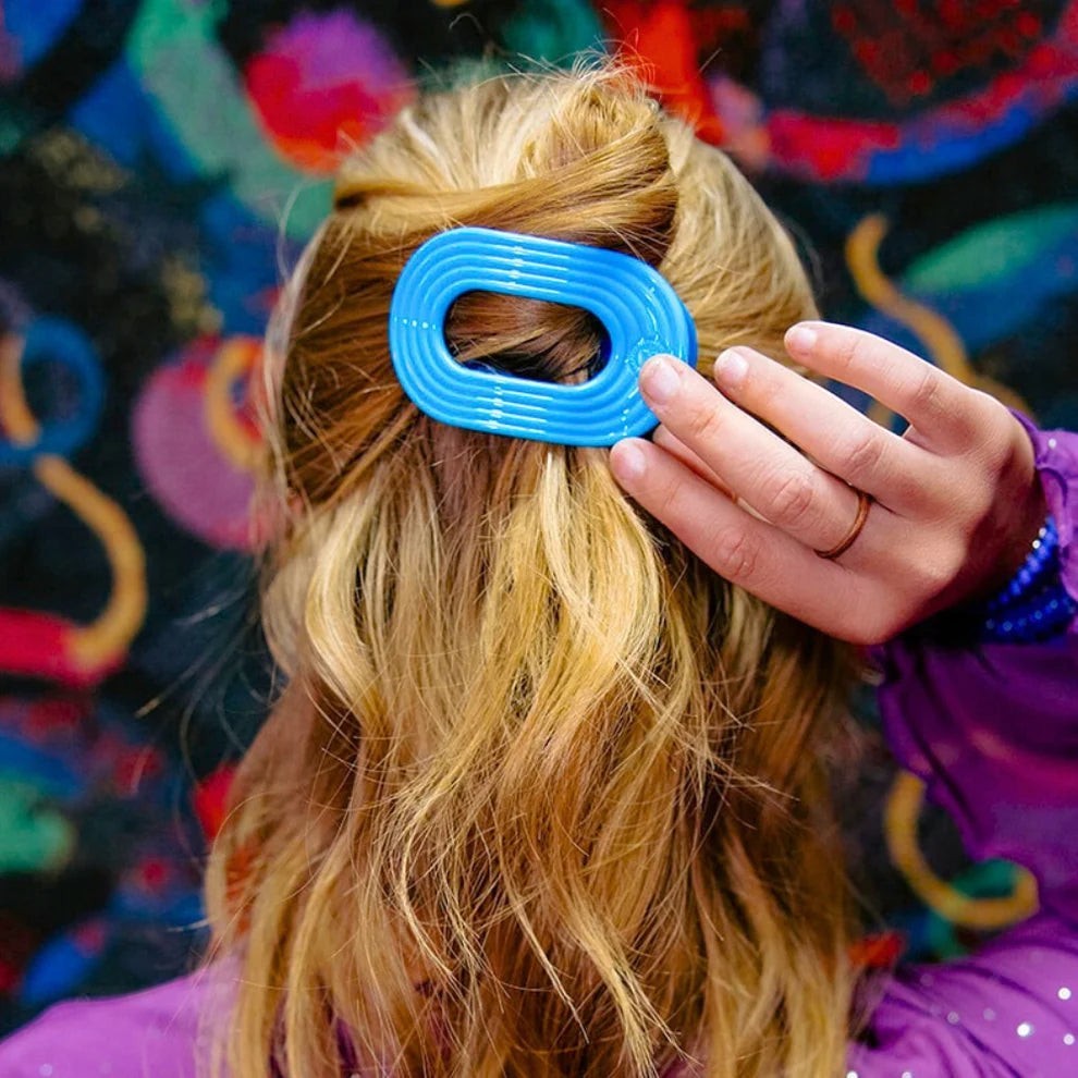 Doodlations Coffee Bar & Boutique vibrant blue flat oval hair clip with ribbed texture for secure styling.